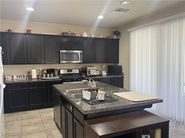 933 Kimbark Ave, Las Vegas, NV 89148 - kitchen featuring stainless steel appliances, a sink, light tile patterned flooring, dark cabinets, and recessed lighting