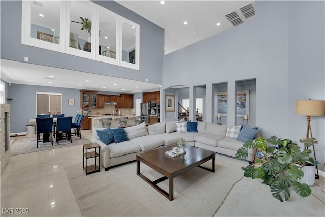 8268 Nelson Ridge Ln, Las Vegas, NV 89178 - living room with arched walkways, a towering ceiling, recessed lighting, light tile patterned floors, and baseboards