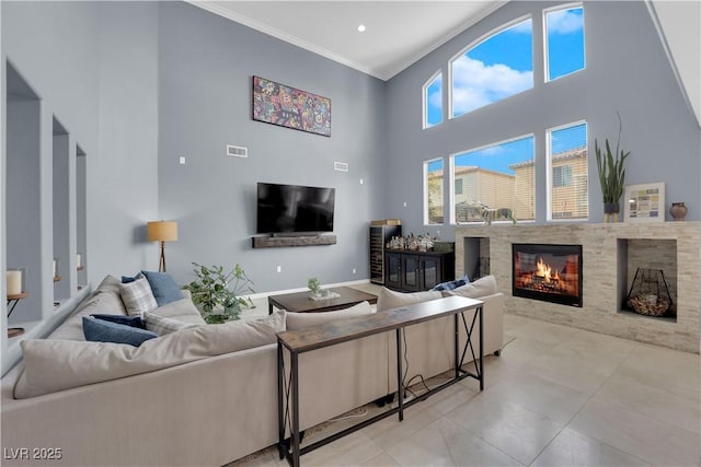 8268 Nelson Ridge Ln, Las Vegas, NV 89178 - living area with ornamental molding, a high ceiling, a glass covered fireplace, and light tile patterned floors