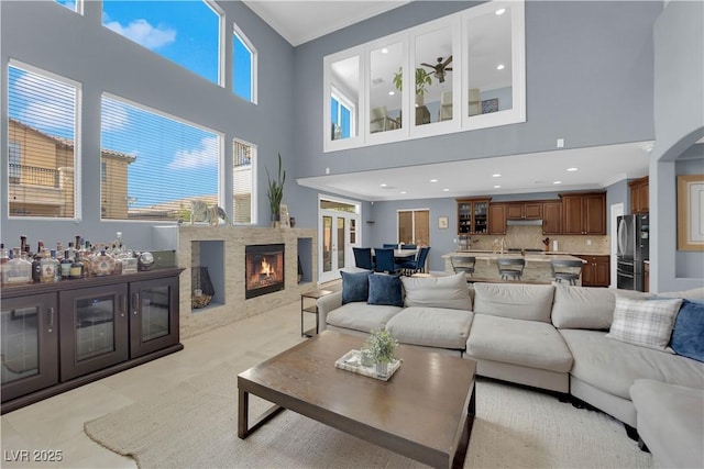 8268 Nelson Ridge Ln, Las Vegas, NV 89178 - living room featuring a towering ceiling, ornamental molding, a warm lit fireplace, and recessed lighting