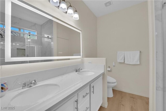 2633 Spider Cactus Ct, Las Vegas, NV 89106 - bathroom with a marble finish shower, double vanity, wood finished floors, toilet, and baseboards