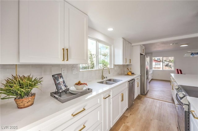 1731 Sherwin Ln, Las Vegas, NV 89156 - kitchen with appliances with stainless steel finishes, a sink, light wood-style flooring, light countertops, and plenty of natural light