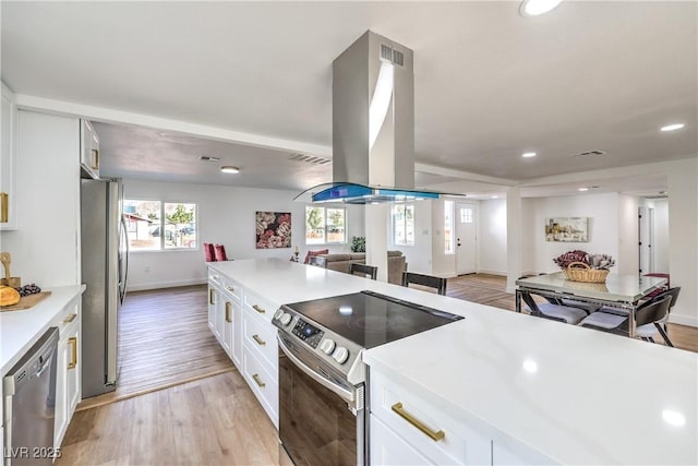 1731 Sherwin Ln, Las Vegas, NV 89156 - kitchen featuring stainless steel appliances, island exhaust hood, open floor plan, light countertops, and light wood finished floors