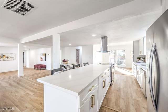 1731 Sherwin Ln, Las Vegas, NV 89156 - kitchen with appliances with stainless steel finishes, island range hood, white cabinets, open floor plan, and recessed lighting