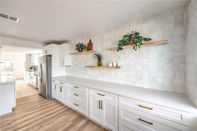 1731 Sherwin Ln, Las Vegas, NV 89156 - kitchen with freestanding refrigerator, open shelves, white cabinetry, and light countertops
