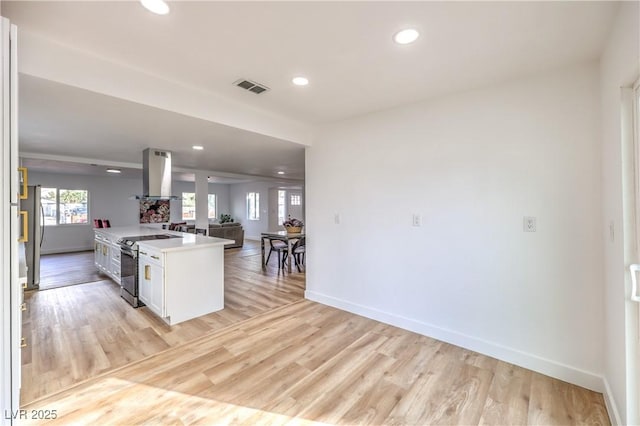1731 Sherwin Ln, Las Vegas, NV 89156 - kitchen with island range hood, stainless steel range with electric cooktop, open floor plan, baseboards, and recessed lighting