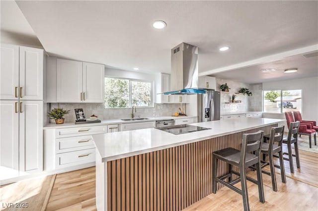 1731 Sherwin Ln, Las Vegas, NV 89156 - kitchen featuring island exhaust hood, appliances with stainless steel finishes, a sink, healthy amount of natural light, and recessed lighting