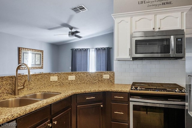 5099 Mascaro Dr, Las Vegas, NV 89122 - kitchen with appliances with stainless steel finishes, a sink, lofted ceiling, decorative backsplash, and white cabinetry