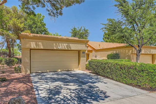 9024 Starmount Dr, Las Vegas, NV 89134 - mediterranean / spanish home featuring stucco siding, concrete driveway, a tile roof, and an attached garage