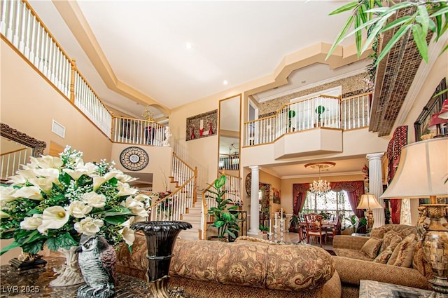 10798 Tapestry Winds St, Las Vegas, NV 89141 - living area featuring a towering ceiling, ornate columns, a chandelier, stairs, and crown molding