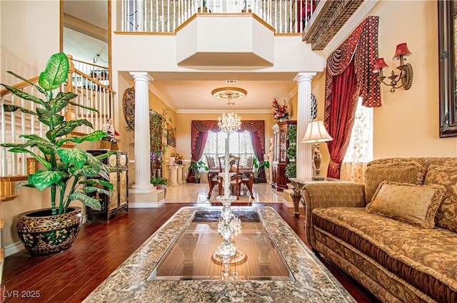 10798 Tapestry Winds St, Las Vegas, NV 89141 - living area featuring ornate columns, a chandelier, wood finished floors, crown molding, and a high ceiling