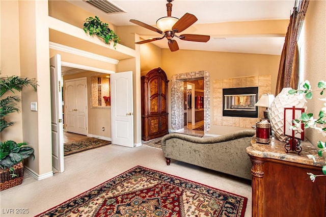10798 Tapestry Winds St, Las Vegas, NV 89141 - carpeted living room featuring ceiling fan, vaulted ceiling, baseboards, and a fireplace