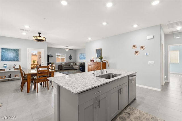 10951 Stone Crossing Ave, Las Vegas, NV 89166 - kitchen featuring a sink, stainless steel dishwasher, gray cabinets, an island with sink, and light stone countertops