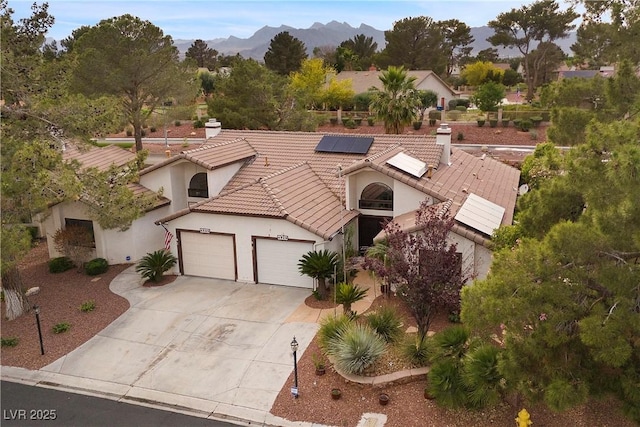 4909 Ocean Shores Way, Las Vegas, NV 89130 - mediterranean / spanish-style home with concrete driveway, an attached garage, stucco siding, solar panels, and a tiled roof