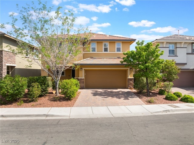 10315 Turia Gardens Rd, Las Vegas, NV 89135 - view of front facade featuring stucco siding, decorative driveway, an attached garage, and stone siding