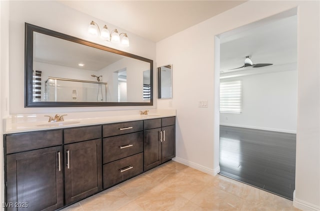 10315 Turia Gardens Rd, Las Vegas, NV 89135 - full bathroom featuring double vanity, a shower with shower door, baseboards, and a ceiling fan