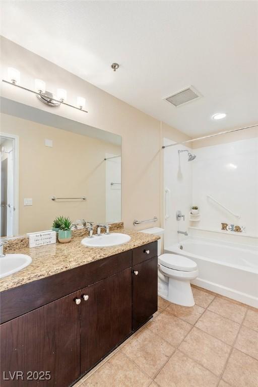 8255 Las Vegas Blvd Unit 117, Las Vegas, NV 89123 - bathroom featuring double vanity, tile patterned flooring, tub / shower combination, and toilet