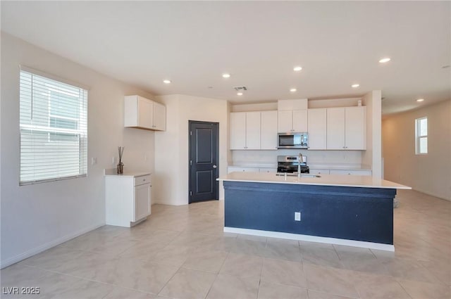 5398 Robinera Ct, Las Vegas, NV 89166 - kitchen featuring appliances with stainless steel finishes, light countertops, a sink, white cabinets, and recessed lighting