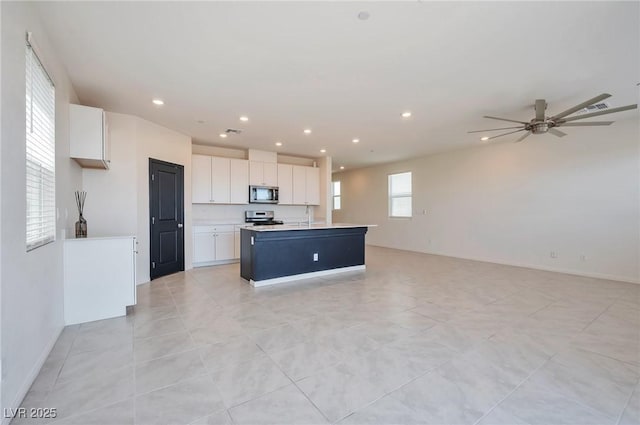 5398 Robinera Ct, Las Vegas, NV 89166 - kitchen featuring stainless steel appliances, open floor plan, a sink, white cabinets, and recessed lighting