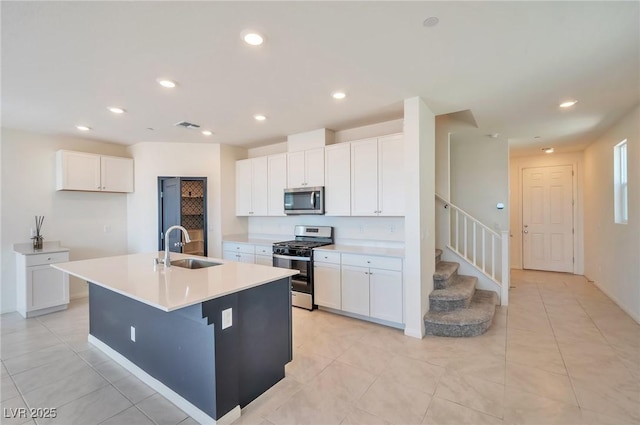5398 Robinera Ct, Las Vegas, NV 89166 - kitchen with appliances with stainless steel finishes, a sink, recessed lighting, white cabinets, and a kitchen island with sink