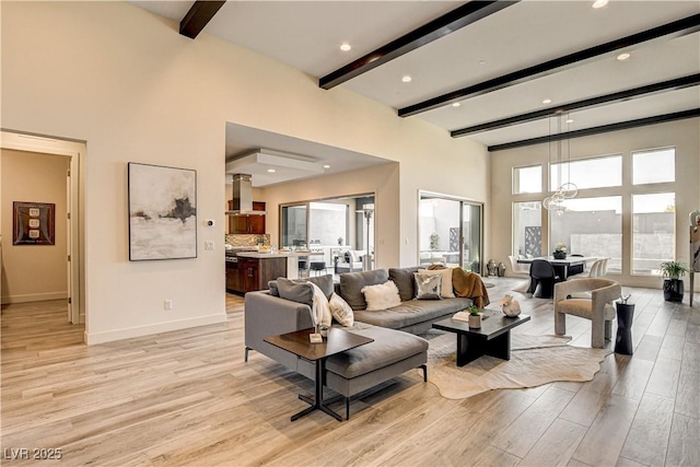 10228 Shell Star Ave, Las Vegas, NV 89135 - living area with beam ceiling, light wood finished floors, baseboards, a high ceiling, and a chandelier