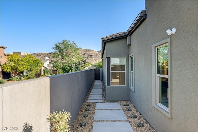 10228 Shell Star Ave, Las Vegas, NV 89135 - view of side of property featuring stucco siding, a balcony, and a mountain view