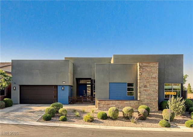 10228 Shell Star Ave, Las Vegas, NV 89135 - view of front of house with a garage, driveway, stone siding, and stucco siding