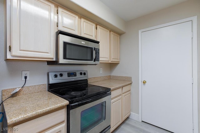 555 E Silverado Ranch Blvd Unit 2164, Las Vegas, NV 89183 - kitchen featuring appliances with stainless steel finishes, light countertops, light wood-style floors, and cream cabinets