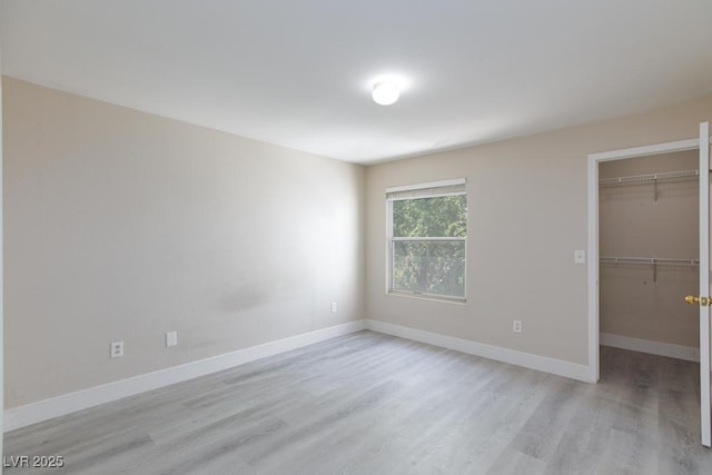 555 E Silverado Ranch Blvd Unit 2164, Las Vegas, NV 89183 - unfurnished bedroom featuring light wood-style floors, a spacious closet, baseboards, and a closet