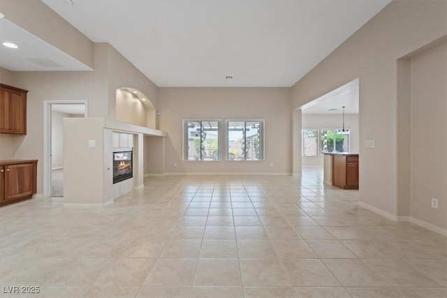 1008 New Creek Ave, Henderson, NV 89015 - unfurnished living room with light tile patterned floors, a tile fireplace, and baseboards
