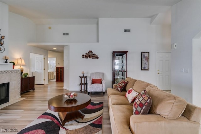 6 Sandwedge Dr, Henderson, NV 89074 - living room featuring high vaulted ceiling, light wood finished floors, and a tiled fireplace