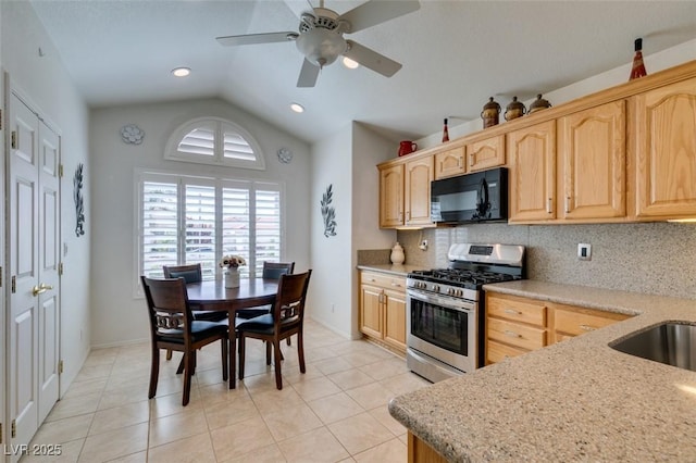 6 Sandwedge Dr, Henderson, NV 89074 - kitchen with stainless steel range with gas cooktop, black microwave, light brown cabinetry, vaulted ceiling, and backsplash