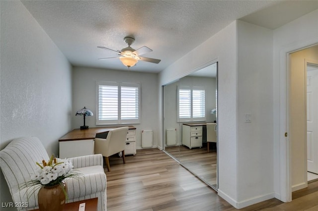 6 Sandwedge Dr, Henderson, NV 89074 - office area featuring light wood-style flooring, a ceiling fan, baseboards, a textured ceiling, and a textured wall