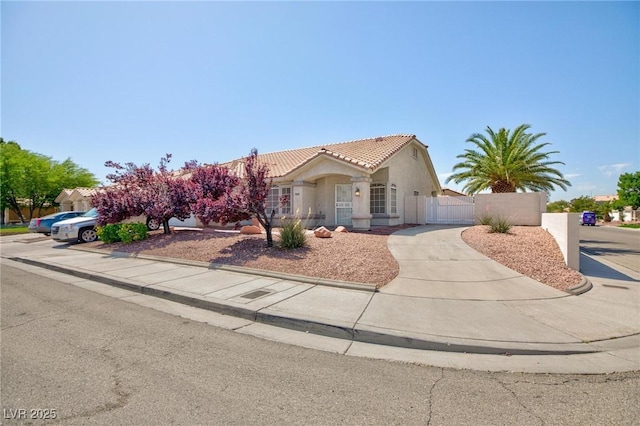 9091 W Viking Rd, Las Vegas, NV 89147 - view of front of house featuring a tile roof, stucco siding, and a gate