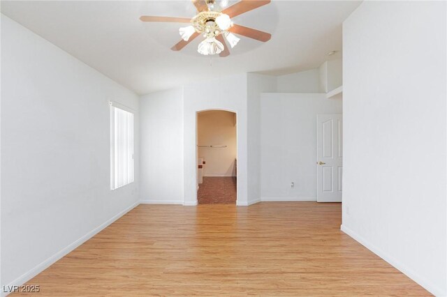 9091 W Viking Rd, Las Vegas, NV 89147 - unfurnished room with arched walkways, light wood-style floors, a ceiling fan, baseboards, and lofted ceiling