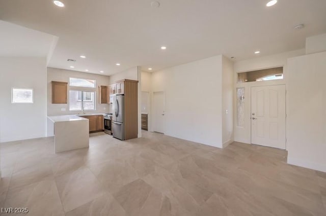10421 Linfield Pl, Las Vegas, NV 89134 - kitchen with appliances with stainless steel finishes, open floor plan, light countertops, recessed lighting, and brown cabinetry