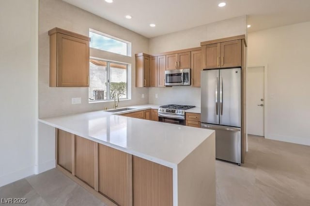 10421 Linfield Pl, Las Vegas, NV 89134 - kitchen with appliances with stainless steel finishes, a sink, a peninsula, light countertops, and recessed lighting