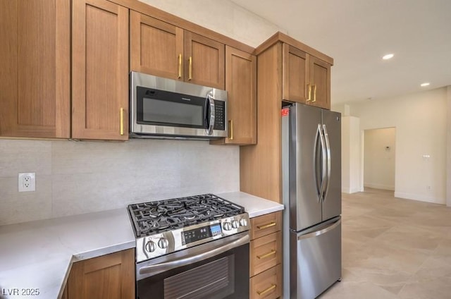 10421 Linfield Pl, Las Vegas, NV 89134 - kitchen featuring appliances with stainless steel finishes, brown cabinets, light countertops, tasteful backsplash, and recessed lighting
