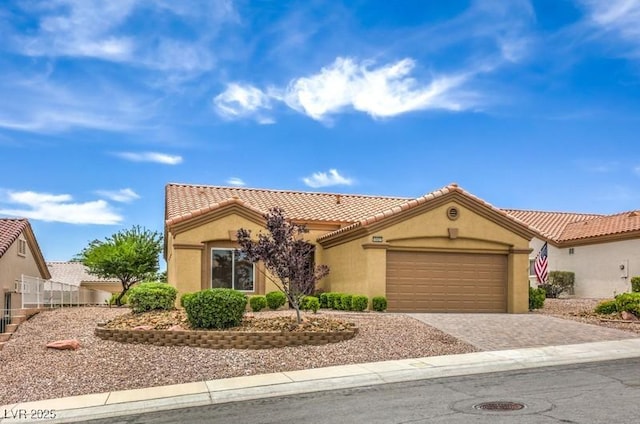 10421 Linfield Pl, Las Vegas, NV 89134 - mediterranean / spanish house with stucco siding, a garage, decorative driveway, and a tiled roof