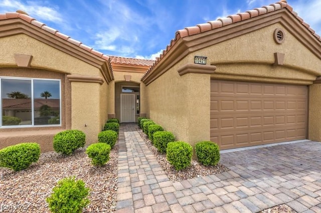 10421 Linfield Pl, Las Vegas, NV 89134 - view of front of home with a tile roof, stucco siding, an attached garage, and decorative driveway