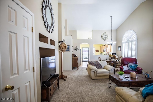 8437 Cinnamon Hill Ave, Las Vegas, NV 89129 - carpeted living area featuring high vaulted ceiling, arched walkways, and a chandelier