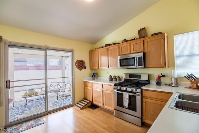 8437 Cinnamon Hill Ave, Las Vegas, NV 89129 - kitchen with appliances with stainless steel finishes, vaulted ceiling, light countertops, light wood-style flooring, and a sink