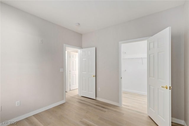7155 S Durango Dr Unit 309, Las Vegas, NV 89113 - unfurnished bedroom featuring light wood-type flooring, a walk in closet, baseboards, and a closet