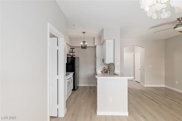7155 S Durango Dr Unit 309, Las Vegas, NV 89113 - kitchen with white range with gas stovetop, ceiling fan, a chandelier, arched walkways, and light wood-style floors