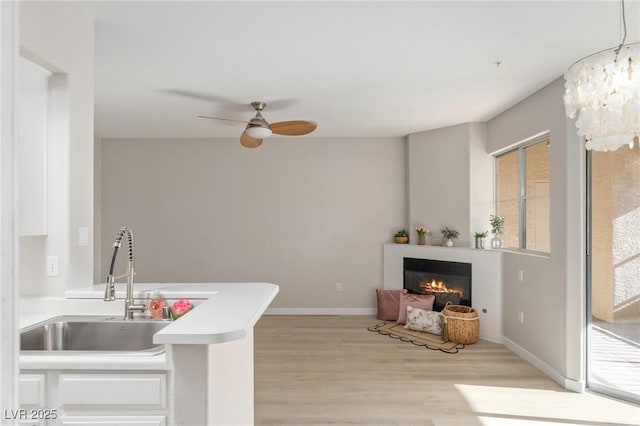 7155 S Durango Dr Unit 309, Las Vegas, NV 89113 - kitchen with light wood-style flooring, plenty of natural light, a ceiling fan, and a sink