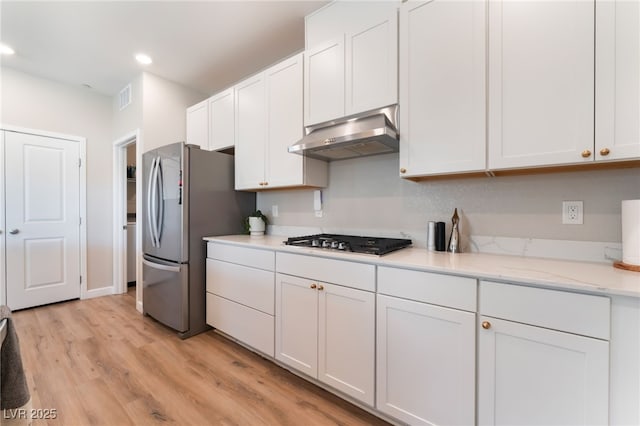 8351 Vinamala Ave, Las Vegas, NV 89149 - kitchen with under cabinet range hood, appliances with stainless steel finishes, white cabinets, light wood finished floors, and recessed lighting