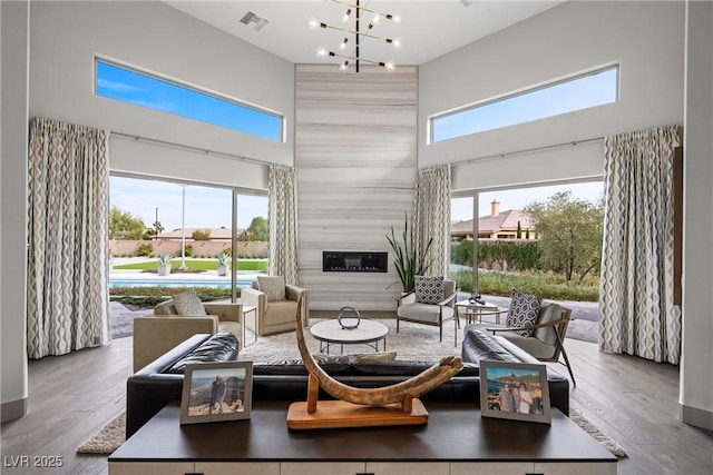 4050 N Tomsik St, Las Vegas, NV 89129 - living area with a high ceiling, wood finished floors, a large fireplace, and a chandelier