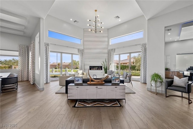 4050 N Tomsik St, Las Vegas, NV 89129 - living room featuring a high ceiling, plenty of natural light, wood-type flooring, and a fireplace