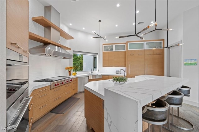 4050 N Tomsik St, Las Vegas, NV 89129 - kitchen featuring stainless steel appliances, light wood-type flooring, modern cabinets, a kitchen island with sink, and open shelves