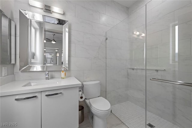 4050 N Tomsik St, Las Vegas, NV 89129 - bathroom with a shower stall, toilet, vanity, tile walls, and a ceiling fan